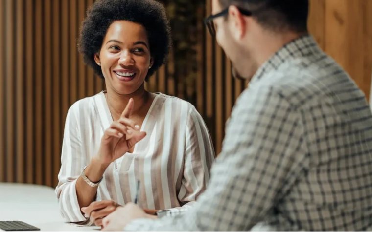 Two people in conversation across a table.